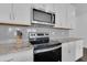 Kitchen featuring stainless steel appliances, granite countertops, and white cabinets at 3017 Ambersweet Pl, Clermont, FL 34711