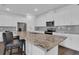 A modern kitchen featuring white cabinets, stainless steel appliances, a spacious island, and a stylish backsplash at 3017 Ambersweet Pl, Clermont, FL 34711