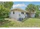 Well-maintained backyard with a lush lawn, mature trees, and modern AC unit, perfect for outdoor living at 318 E Jersey St, Orlando, FL 32806