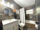 Bathroom with slate-style tiled walls, contemporary vanity, and a shower-tub with patterned curtain at 318 E Jersey St, Orlando, FL 32806