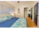 Bedroom with hardwood floors, closet and window, featuring a large bed with patterned bedspread at 318 E Jersey St, Orlando, FL 32806