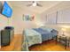 Bedroom featuring hardwood floors, a patterned duvet on the bed, and a wall-mounted TV at 318 E Jersey St, Orlando, FL 32806