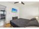 Bright bedroom features a ceiling fan, hardwood floors, and a wall-mounted television for comfortable living at 318 E Jersey St, Orlando, FL 32806