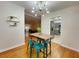 Cozy dining area featuring modern lighting fixture, wood floors, and seamless open to living room at 318 E Jersey St, Orlando, FL 32806