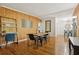 Dining room with wood-paneled walls, hardwood floors, stylish furniture, and seamless access to the living area at 318 E Jersey St, Orlando, FL 32806