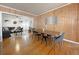 Open concept dining room that flows from the living room, boasting beautiful wood floors and a stylish wood feature wall at 318 E Jersey St, Orlando, FL 32806