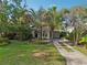 Charming home with lush landscaping, palm trees, and a inviting driveway, creating excellent curb appeal at 318 E Jersey St, Orlando, FL 32806