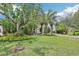 Captivating front yard with mature palm trees, manicured lawn, and welcoming facade, enhancing the property's charm at 318 E Jersey St, Orlando, FL 32806