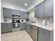 Updated kitchen boasts gray cabinets, stainless steel appliances, and stylish tile backsplash at 318 E Jersey St, Orlando, FL 32806