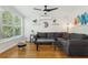 A cozy living room with large window, comfortable sectional, modern ceiling fan and sleek decor at 318 E Jersey St, Orlando, FL 32806