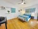 Cozy main bedroom featuring natural light, hardwood floors, and a bench at the foot of the bed at 318 E Jersey St, Orlando, FL 32806