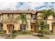 Charming tan townhome with shutters, palm trees, and well-maintained brick-paved driveway at 3643 Calabria Avenue, Davenport, FL 33897