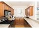 Compact kitchen featuring stainless steel appliances, granite countertops, and wood cabinets at 3643 Calabria Avenue, Davenport, FL 33897