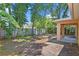 Large backyard with trees, banana trees, and view from under the covered back porch at 3795 Rachel St, Apopka, FL 32703