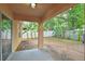 A covered back porch overlooks a spacious backyard with banana trees and a white fence at 3795 Rachel St, Apopka, FL 32703