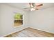 Well-lit bedroom features wood-look flooring, fan, and view of the backyard at 3795 Rachel St, Apopka, FL 32703