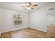 Bedroom features ceiling fan, wood-look floors and backyard view at 3795 Rachel St, Apopka, FL 32703