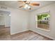 This bedroom includes a ceiling fan, wood-look floors, and backyard view at 3795 Rachel St, Apopka, FL 32703