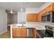 Modern kitchen featuring stainless steel appliances, wood cabinetry, and a breakfast bar for additional seating at 3795 Rachel St, Apopka, FL 32703