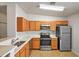Well-equipped kitchen with stainless steel appliances, light wood cabinets, and white countertops at 3795 Rachel St, Apopka, FL 32703