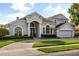Two-story home with a paved driveway, arched windows, and lush landscaping at 3891 Brantley Place Cir, Apopka, FL 32703