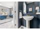Chic half bath features a pedestal sink, gold accents, and a navy blue accent wall at 3891 Brantley Place Cir, Apopka, FL 32703