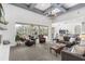 Open-concept living room with a fireplace, comfortable seating, and views of the pool area and kitchen at 3891 Brantley Place Cir, Apopka, FL 32703