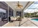 Enclosed lanai featuring outdoor seating, ceiling fan, and a partial view of the pool at 3891 Brantley Place Cir, Apopka, FL 32703