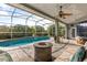 Enclosed lanai with seating and fire pit overlooking the beautiful backyard pool at 3891 Brantley Place Cir, Apopka, FL 32703