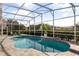 Enclosed lanai with outdoor seating overlooking the backyard pool with waterfall at 3891 Brantley Place Cir, Apopka, FL 32703