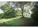 A large backyard featuring a lush lawn and mature trees at 4141 Fallwood Cir, Orlando, FL 32812