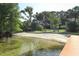 Serene waterfront area with sandy beach, benches, playground, and lush trees at 4141 Fallwood Cir, Orlando, FL 32812
