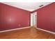 Empty bedroom with striped wallpaper and light wood flooring at 4141 Fallwood Cir, Orlando, FL 32812