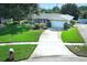 Charming single-story home with a well-manicured lawn, mature trees, and a cozy front porch at 4141 Fallwood Cir, Orlando, FL 32812