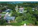 Aerial view showcases a tranquil neighborhood with mature trees and a glimpse of a serene lake at 4141 Fallwood Cir, Orlando, FL 32812