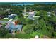 Aerial view showcases a tranquil neighborhood with mature trees and a glimpse of a serene lake at 4141 Fallwood Cir, Orlando, FL 32812