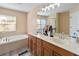 This is an oversized bathroom with a double sink vanity, soaking tub, and a separate glass enclosed shower at 4751 Aguila Pl, Orlando, FL 32826