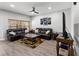 Cozy living room with luxury vinyl plank flooring, a ceiling fan, dark leather sofas, and natural light at 4751 Aguila Pl, Orlando, FL 32826