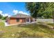 Exterior shot of a home highlighting the enclosed patio and fenced backyard with mature trees at 514 Richmond Ave, Deltona, FL 32725
