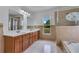 Bright bathroom with a double vanity, tub with shower and glass enclosure at 514 Richmond Ave, Deltona, FL 32725