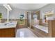 Bright bathroom featuring a double vanity, soaking tub, and glass shower with decorative tile at 514 Richmond Ave, Deltona, FL 32725