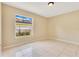 Bright bedroom featuring neutral walls and tile flooring, illuminated by natural light through a window at 514 Richmond Ave, Deltona, FL 32725