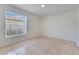 Bright bedroom featuring neutral walls, tile flooring and a window overlooking the backyard at 514 Richmond Ave, Deltona, FL 32725