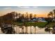 Waterfront home at sunset features a manicured lawn, private dock, and serene lake views at 6139 Greatwater Dr, Windermere, FL 34786