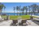 Expansive backyard with lake view features manicured lawn, patio, and access to the water at 6139 Greatwater Dr, Windermere, FL 34786