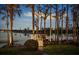 Lakeside dock with charming gazebo and stairs, surrounded by mature trees, reflecting in the water at 6139 Greatwater Dr, Windermere, FL 34786
