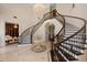 Magnificent foyer featuring a curved staircase, marble floors, and a dazzling chandelier at 6139 Greatwater Dr, Windermere, FL 34786