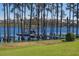 Beautiful lake view featuring a dock and boat cover, surrounded by trees at 6139 Greatwater Dr, Windermere, FL 34786