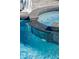 Close-up of the sparkling pool featuring a stone waterfall and mosaic tile detailing at 6139 Greatwater Dr, Windermere, FL 34786