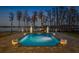 Luxurious pool with elegant statuary, lush landscaping, and serene lake views at twilight at 6139 Greatwater Dr, Windermere, FL 34786